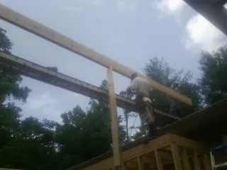Carpenter setting a ridge beam over a new addition frame — Ice Dam Removal by Roofing Brothers in Sikeston
