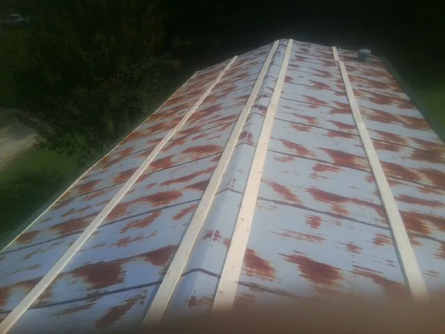 Rusted metal roof panels with new wood purlins before replacement — Storm Damage Roof Repair in Sikeston by Roofing Brothers