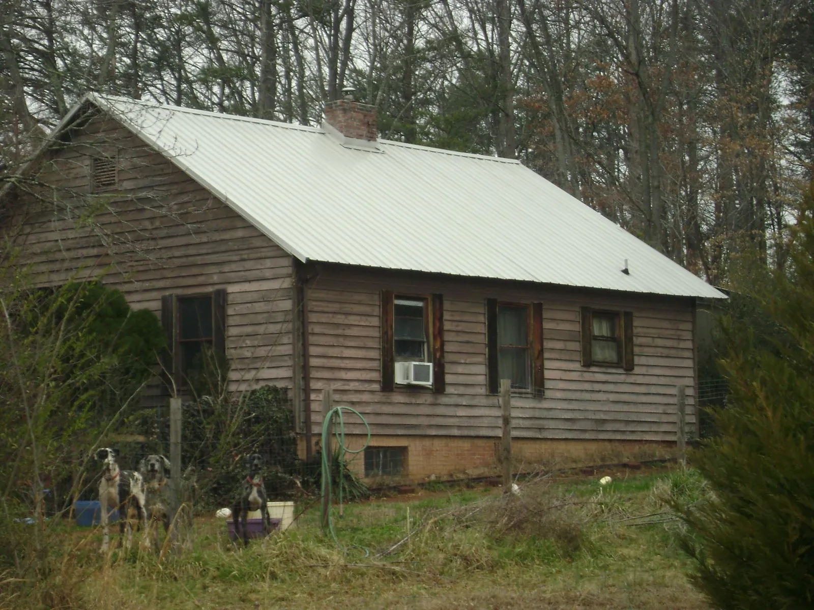 White metal roof on an old wood sided farmhouse, from a Metal Roof Installation job in Sikeston